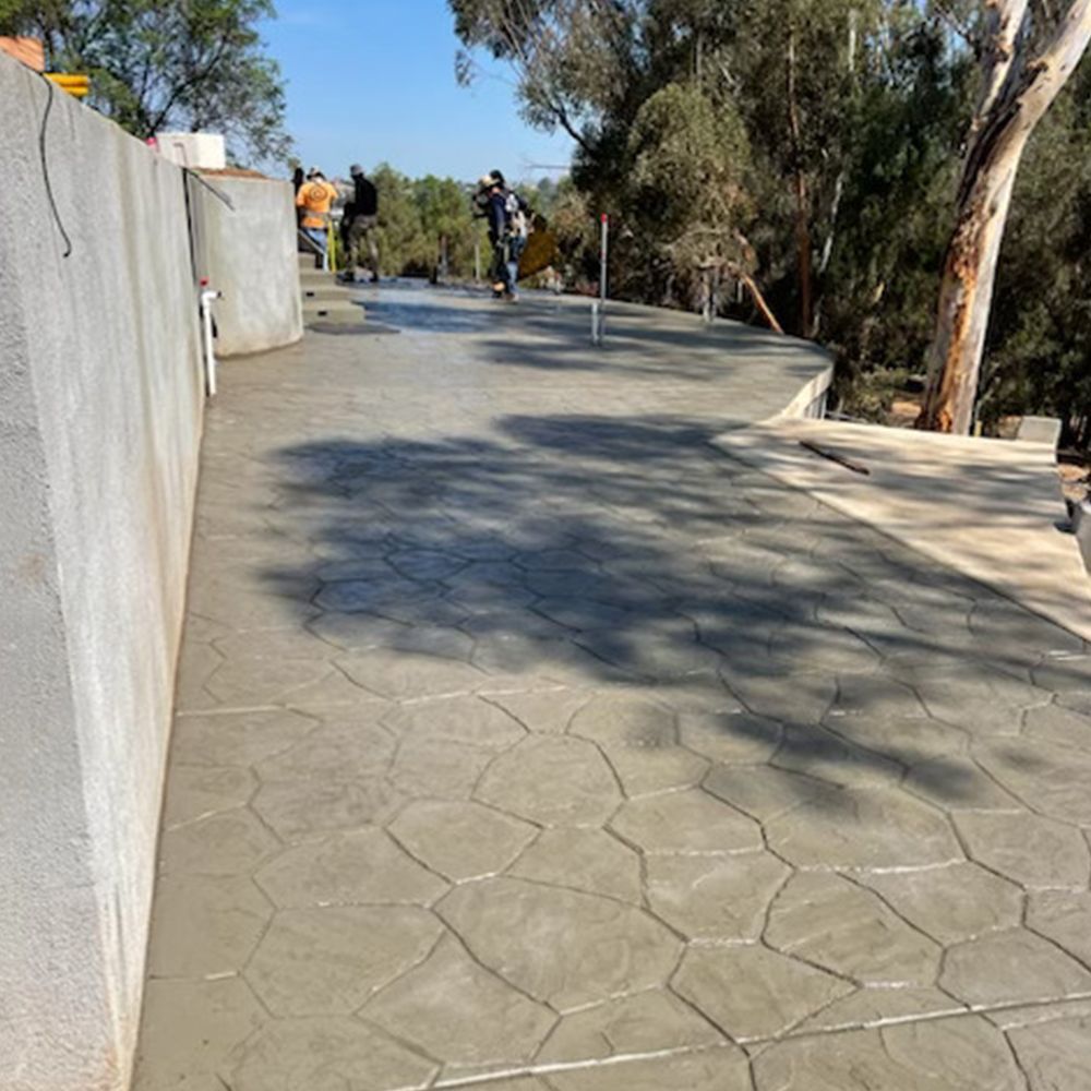 A concrete walkway with trees in the background