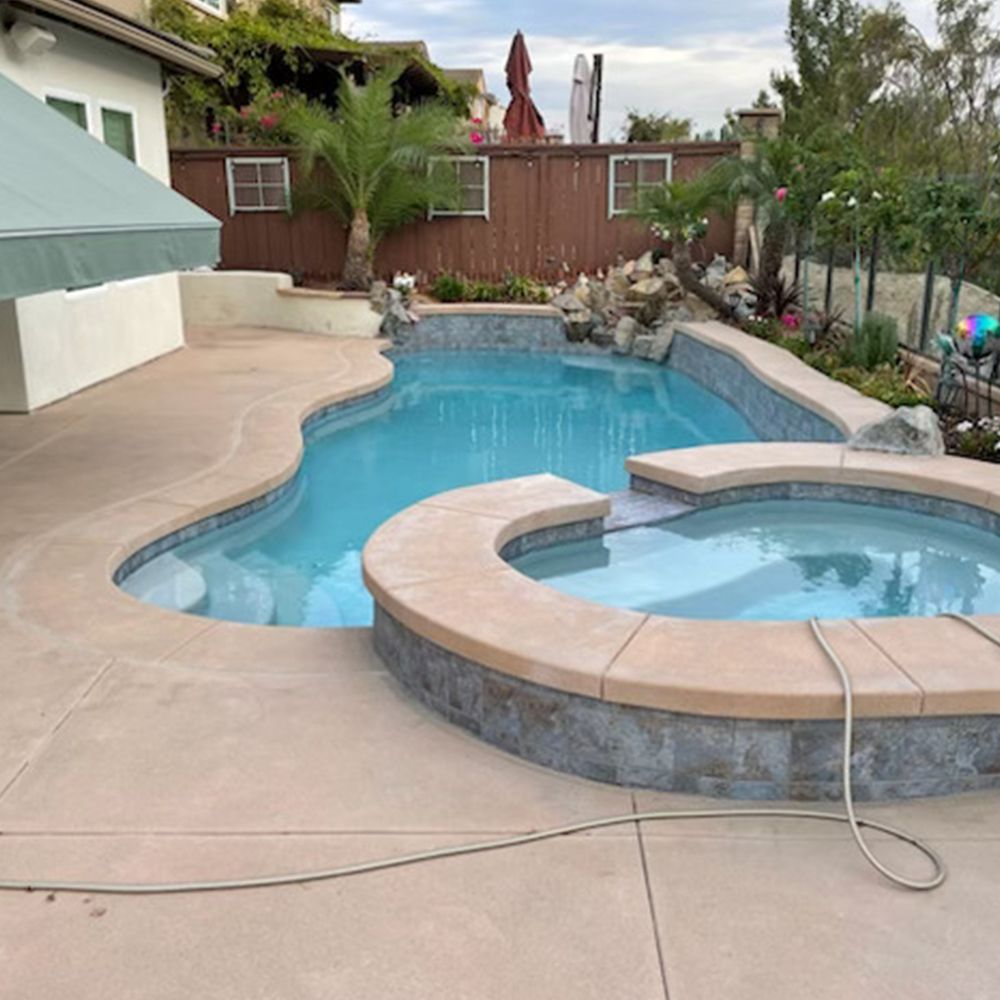 A large swimming pool with a hot tub next to it