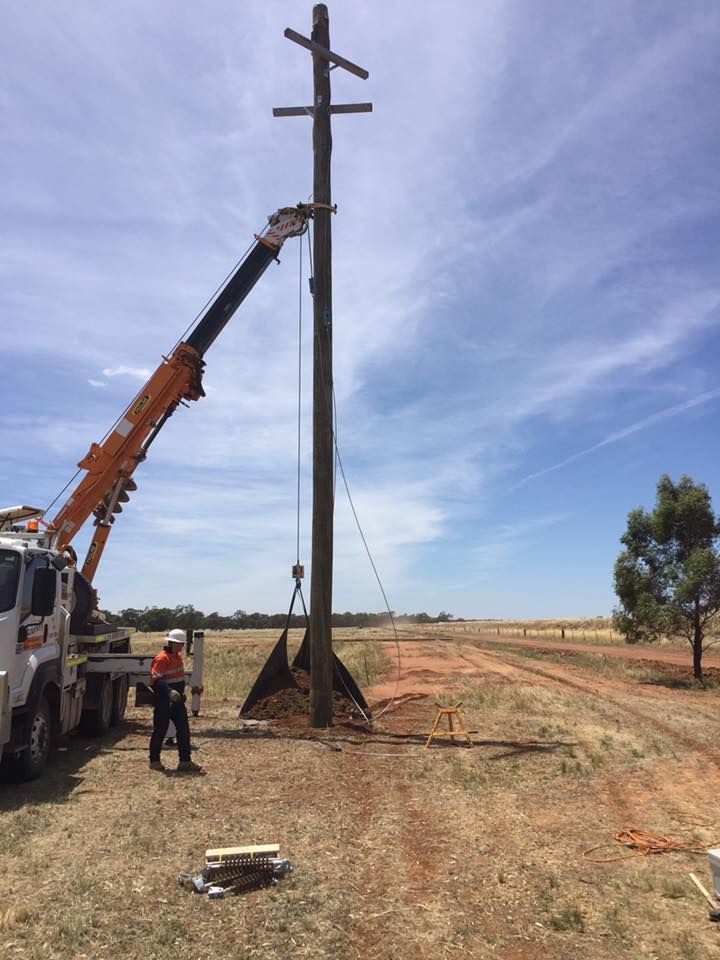 A Crane is Lifting a Pole in a Field — Country Powerline Constructions in Wagga Wagga, NSW
