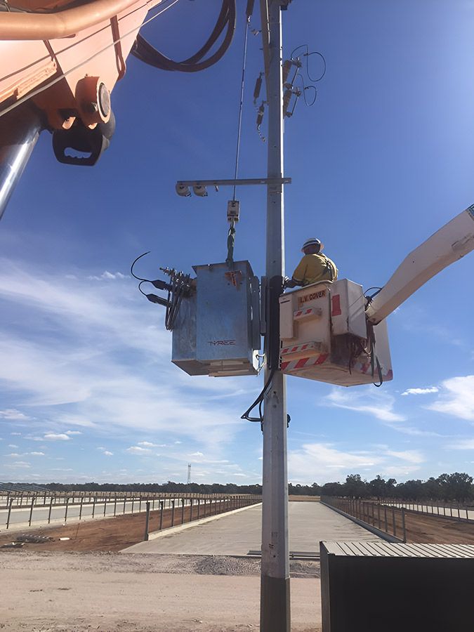 A Man in a Bucket is Working on a Pole — Country Powerline Constructions in Griffith, NSW