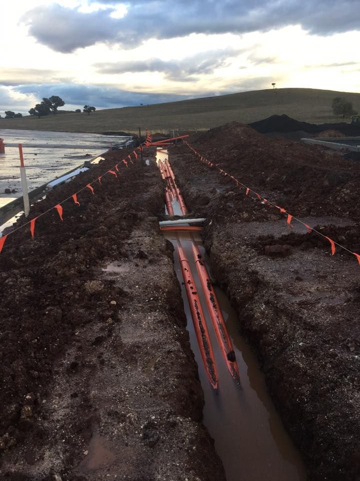 A Muddy Area With a Lot of Orange Flags on It — Country Powerline Constructions in Gunnedah, NSW