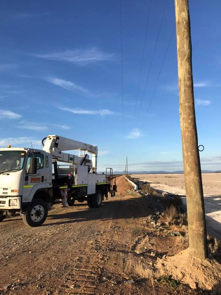 A Truck is Parked Next to a Power Pole on a Dirt Road — Country Powerline Constructions in Gunnedah, NSW
