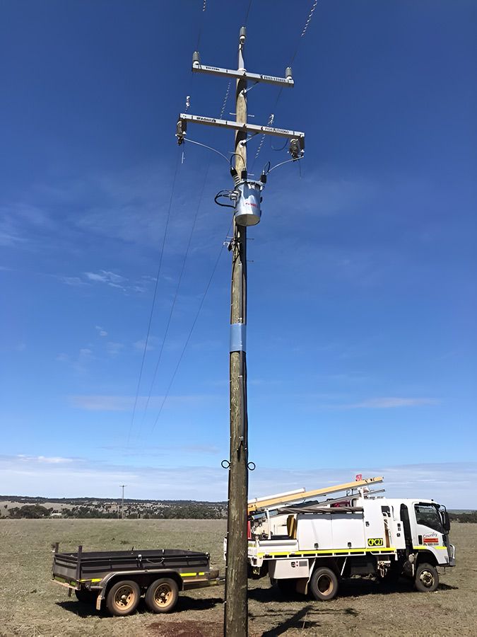 A Truck is Parked Next to a Power Pole in a Field — Country Powerline Constructions in Cowra, NSW