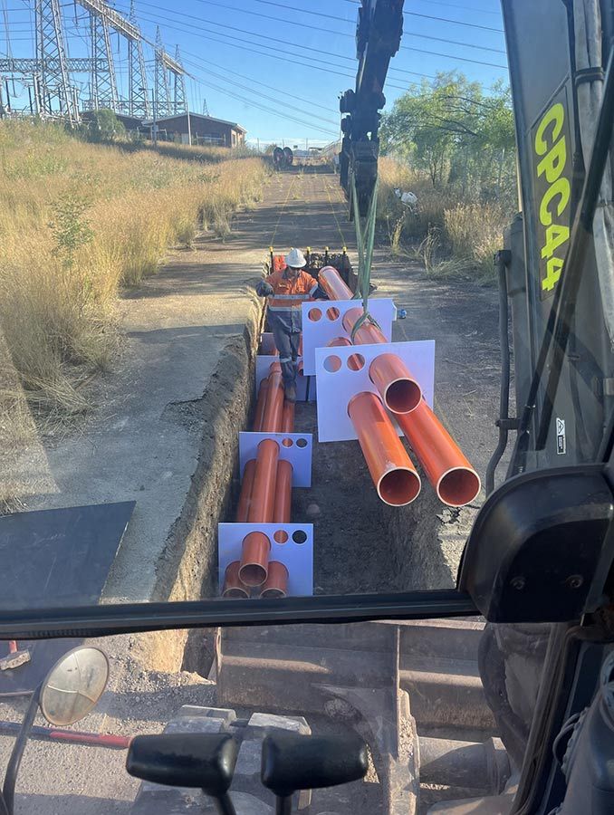 A Truck is Carrying a Bunch of Orange Pipes — Country Powerline Constructions in Dubbo, NSW