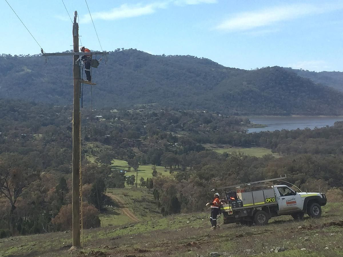 A Truck is Parked on a Hill Next to a Power Line — Country Powerline Constructions in Dubbo, NSW