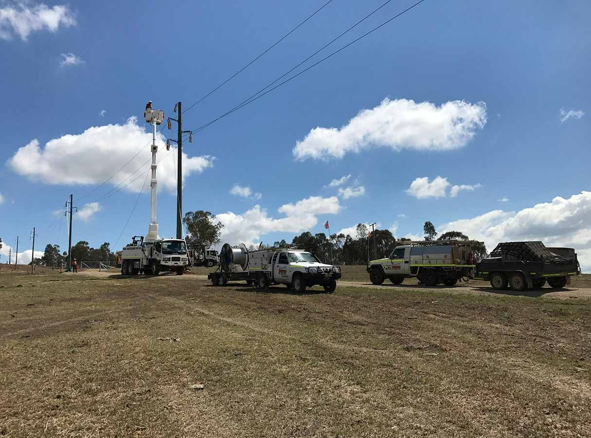 A Group of Trucks Are Parked in a Field Next to Power Lines — Country Powerline Constructions in Parkes, NSW