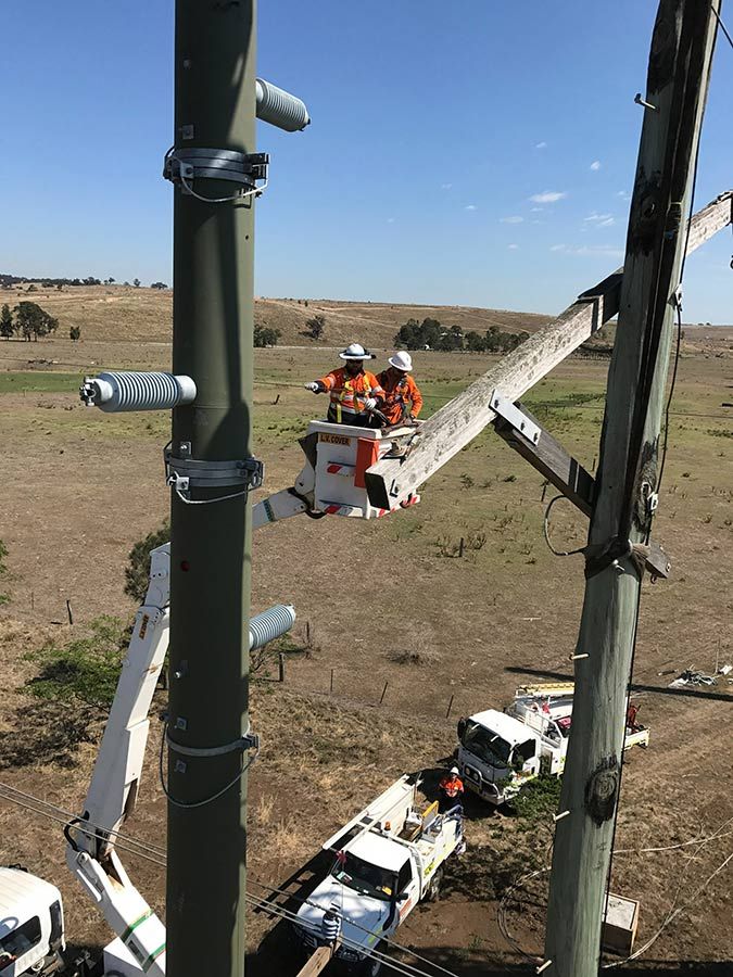 Two Men Are Working on a Pole With a Crane — Country Powerline Constructions in Griffith, NSW
