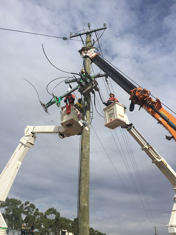 A Group of People Are Working on a Power Pole With a Crane — Country Powerline Constructions in Bathurst, NSW
