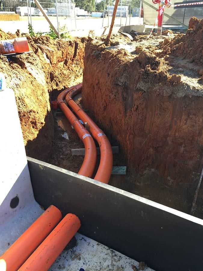 A Bunch of Orange Pipes Are Laying in the Dirt — Country Powerline Constructions in Walget, NSW