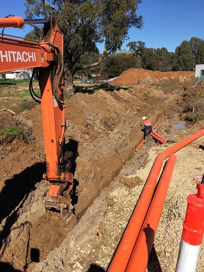 A Hitachi Excavator is Digging a Hole in the Dirt — Country Powerline Constructions in Coonamble, NSW