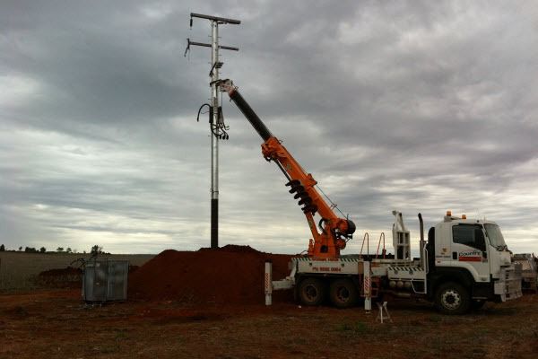 A White Truck With a Crane Attached to the Back of It — Country Powerline Constructions in Dubbo, NSW