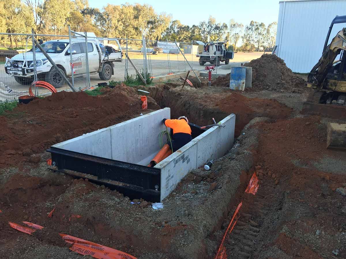 A Man is Digging a Hole in the Dirt in a Construction Site — Country Powerline Constructions in Dubbo, NSW