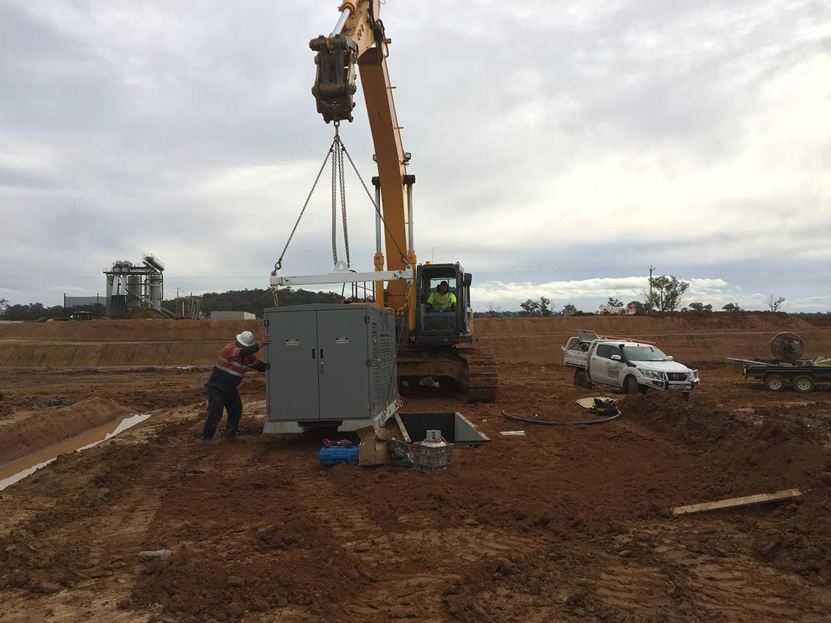 A Construction Site With a Crane Lifting a Box — Country Powerline Constructions in Dubbo, NSW