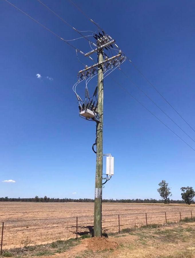A Telephone Pole in the Middle of a Field With a Blue Sky in the Background — Country Powerline Constructions in Dubbo, NSW