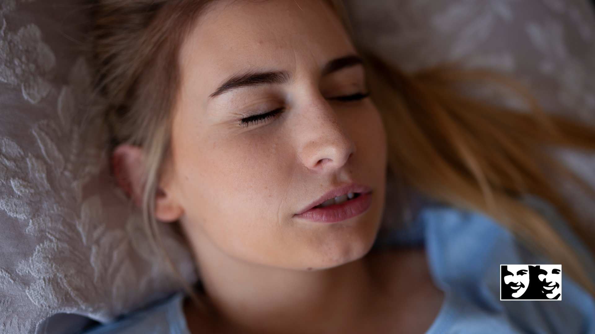 A woman is laying on a bed with her eyes closed.