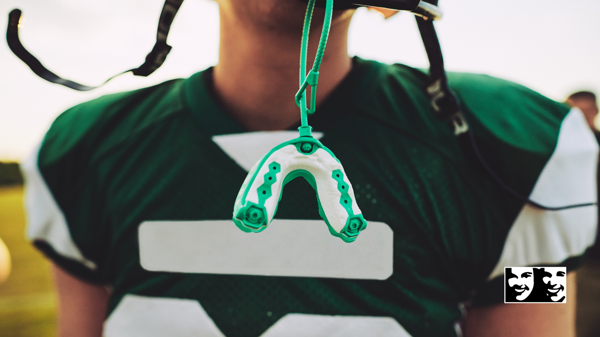 A football player with a mouth guard hanging from his mouth