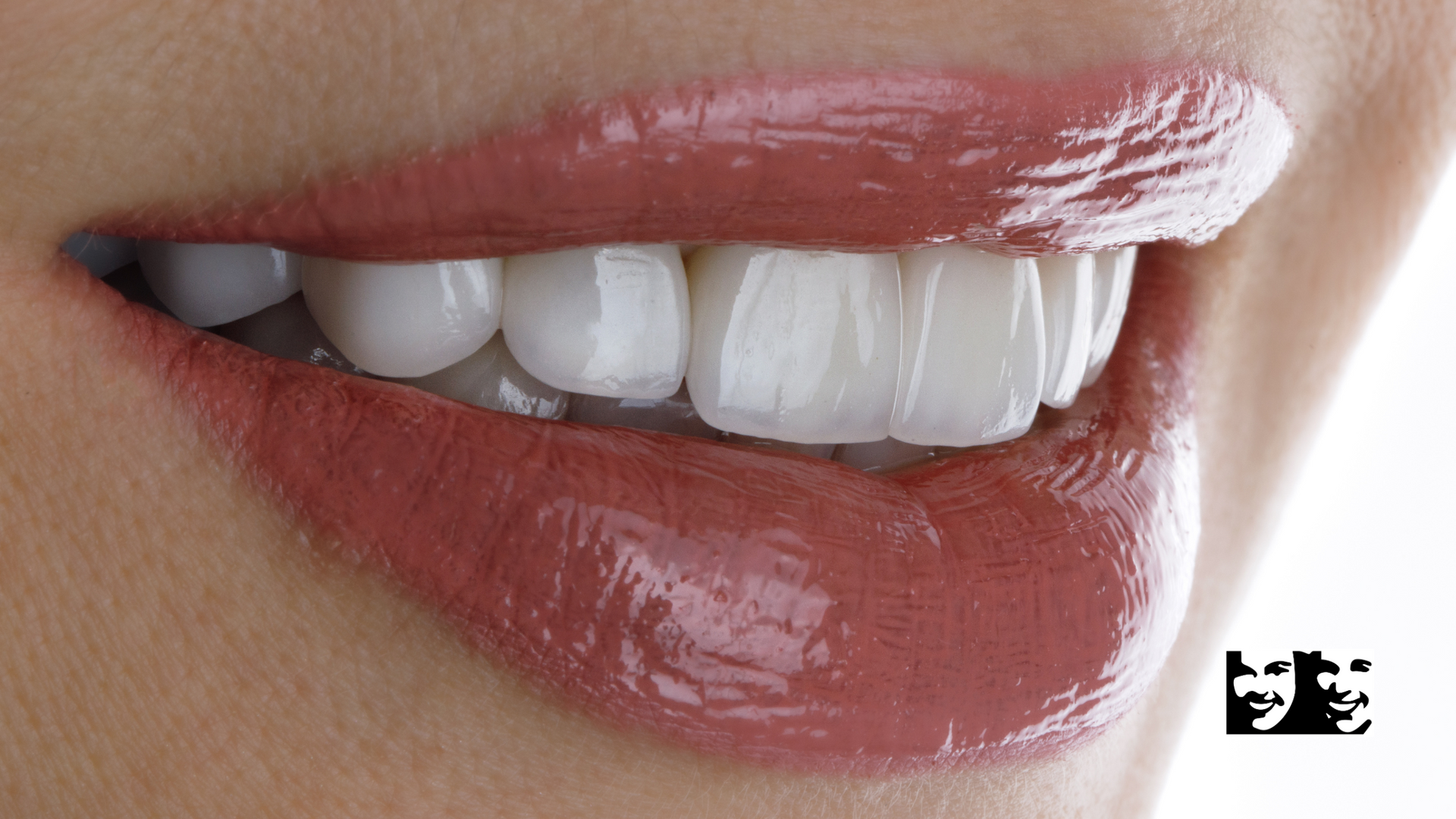 A close up of a woman 's mouth with white teeth and red lips.