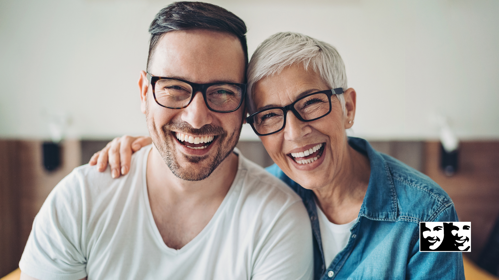 A man and a woman wearing glasses are smiling for the camera.