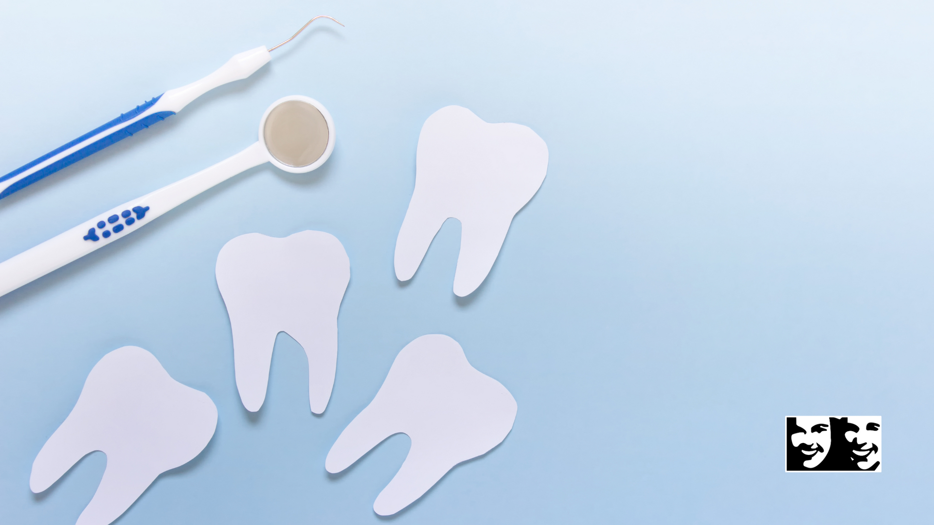 A dental mirror , toothbrush and toothpaste on a blue background