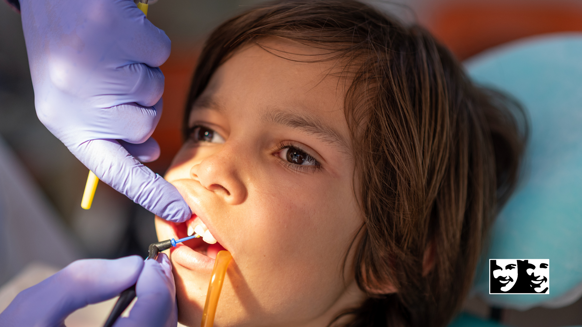A young boy is getting his teeth examined by a dentist.