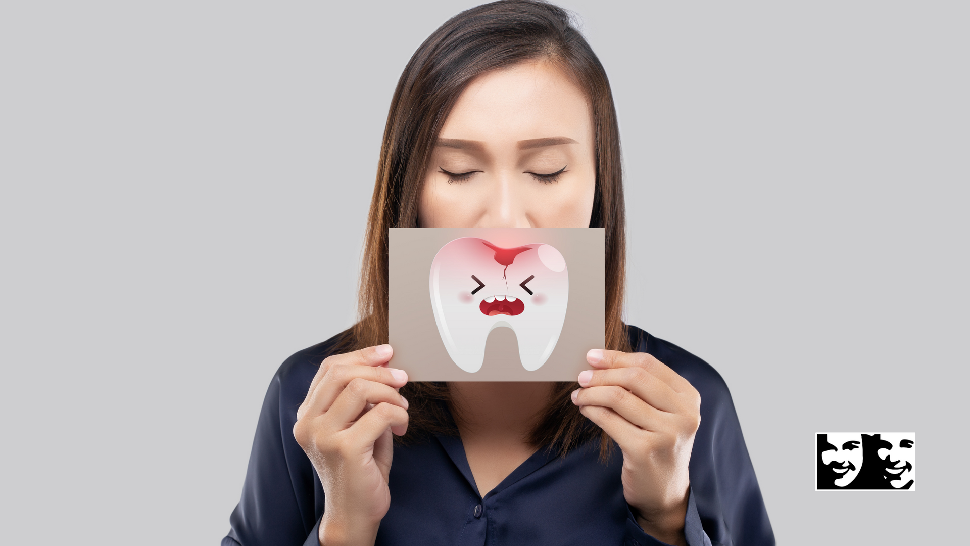 A woman is holding a picture of a tooth with a hole in it.