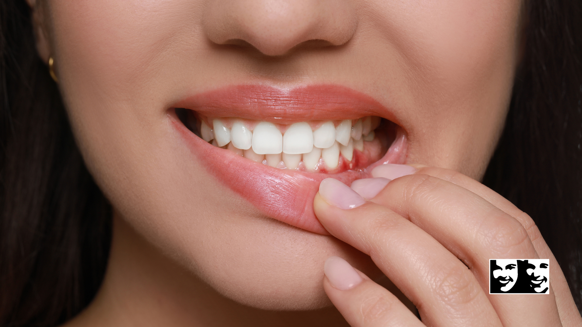 A close up of a woman 's mouth with her hand on her teeth