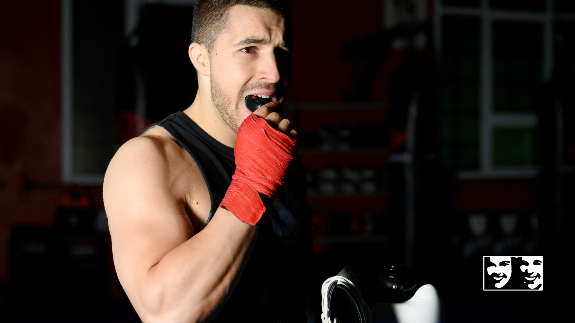 A man wearing boxing gloves and a mouth guard