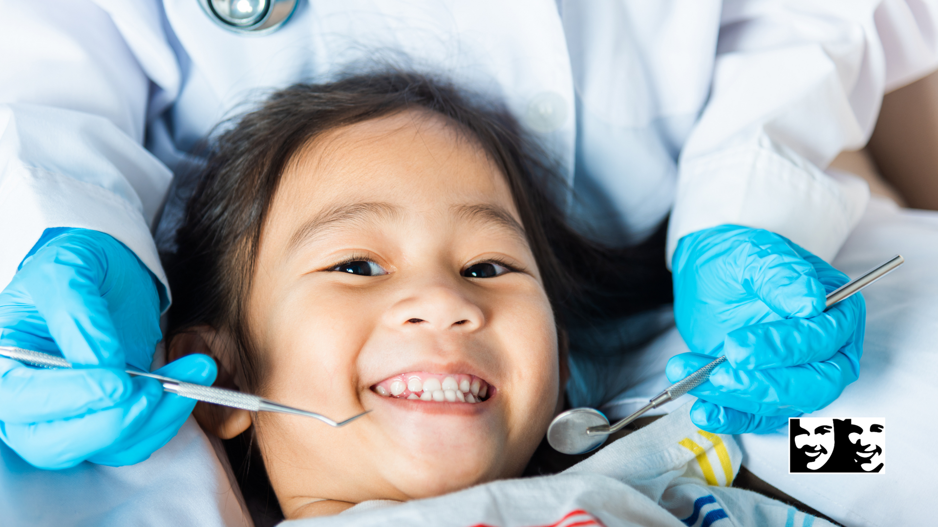 A little girl is getting her teeth examined by a dentist.