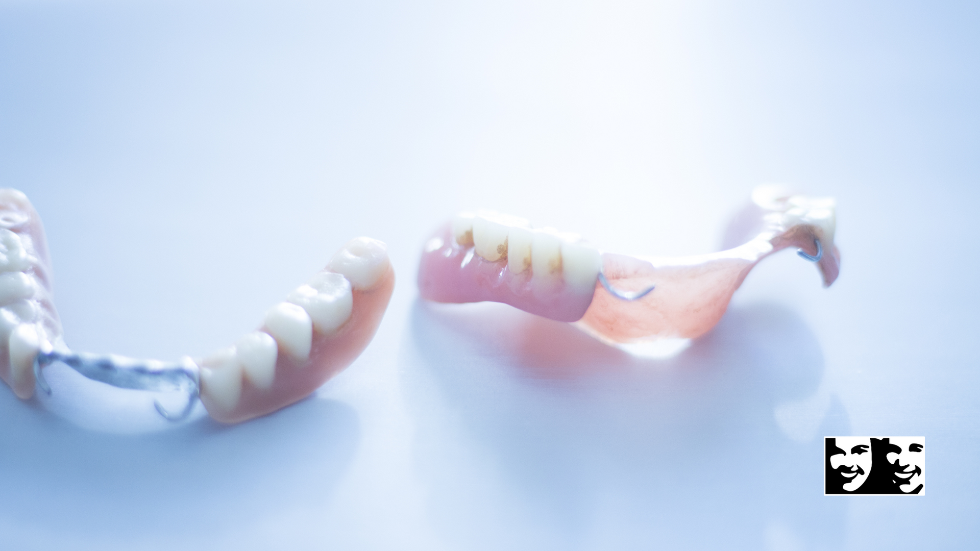 A pair of dentures are laying on a white surface.