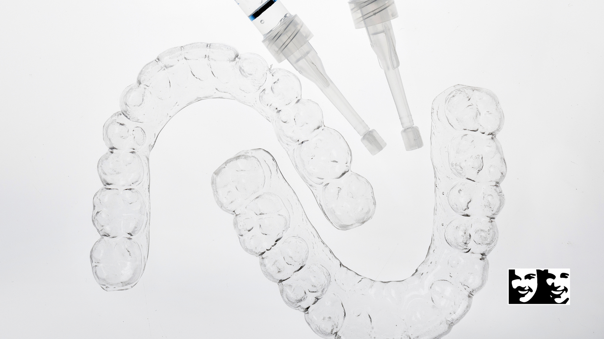 A close up of a tooth whitening kit on a white surface.