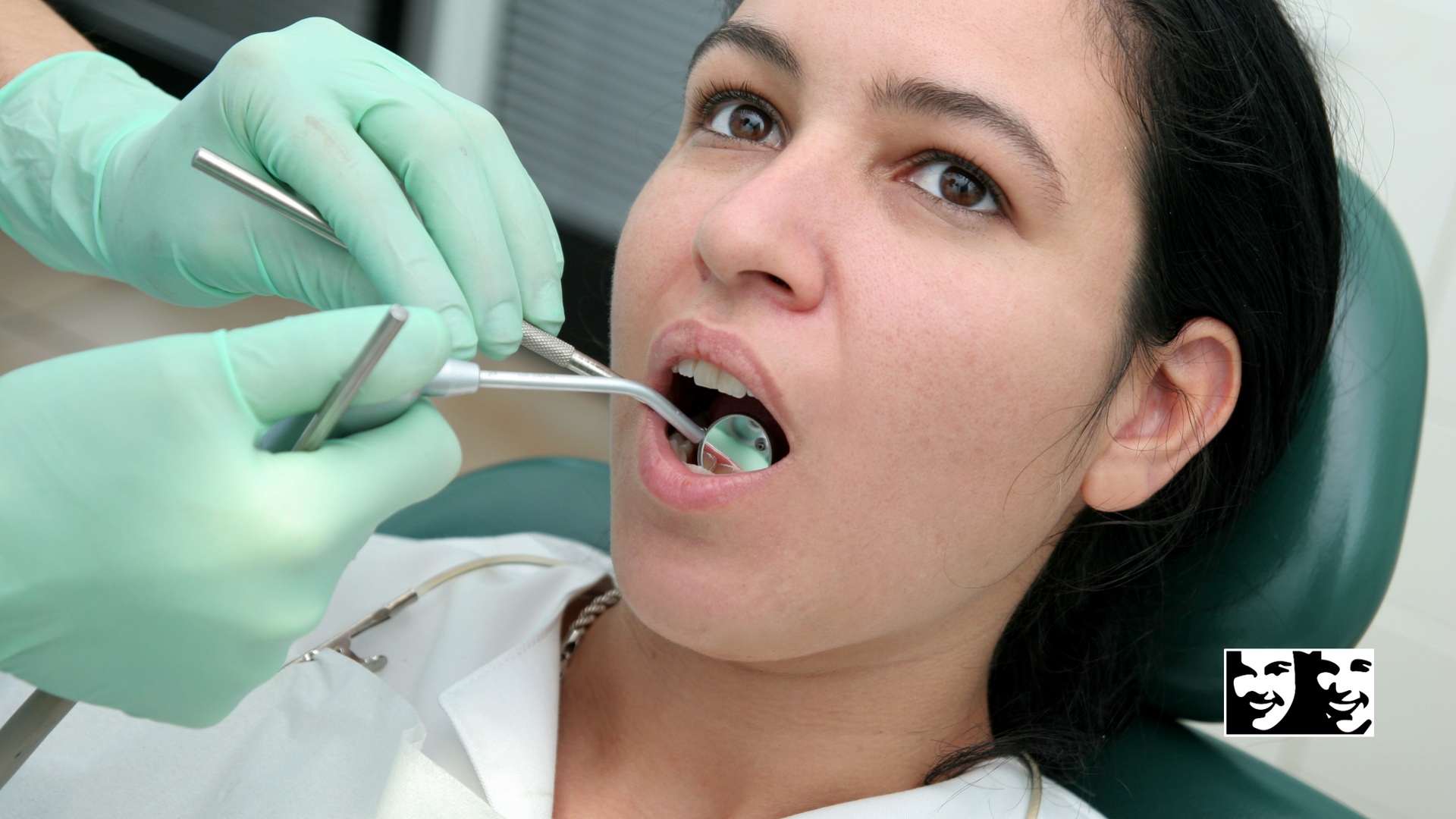 A woman is getting her teeth examined by a dentist