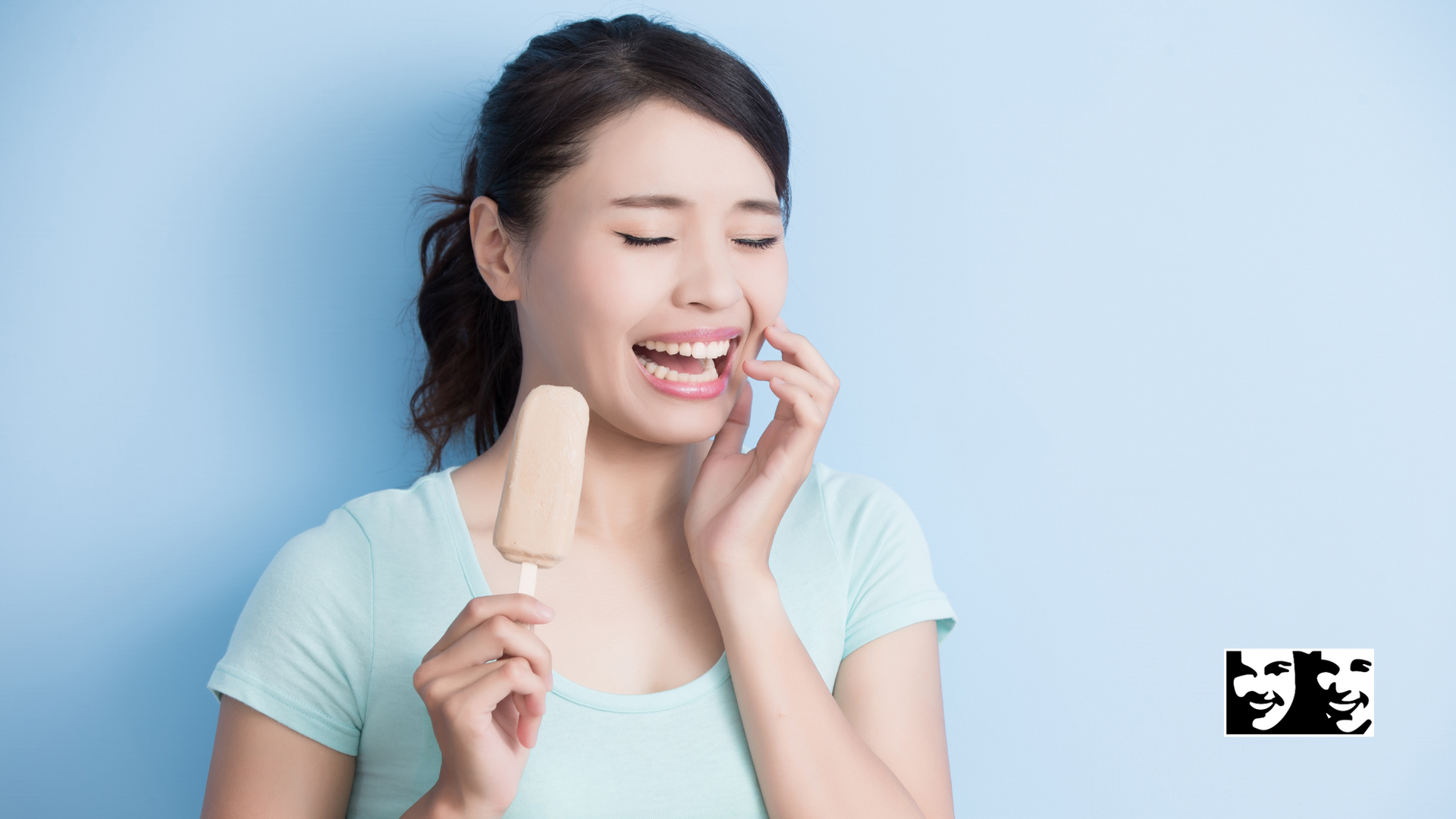 Woman with ice cream experiencing tooth sensitivity; blue background.