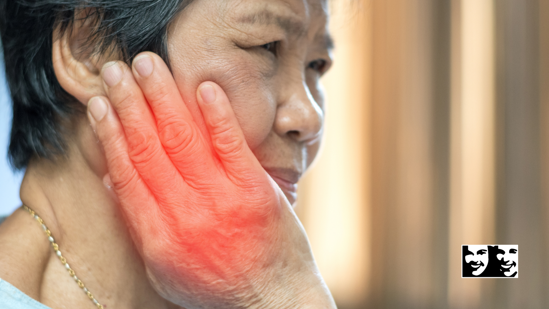 A woman is holding her face in pain because of a toothache.