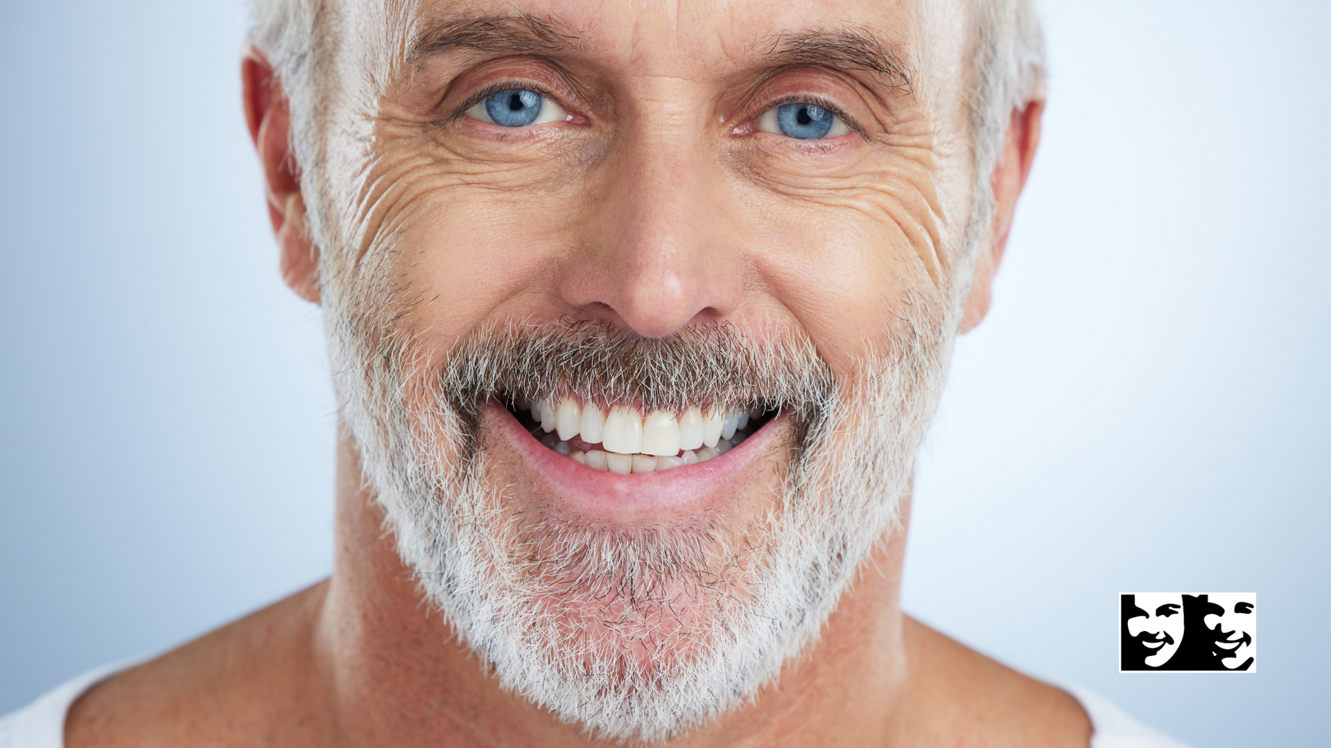 A man with a beard and blue eyes is smiling for the camera.