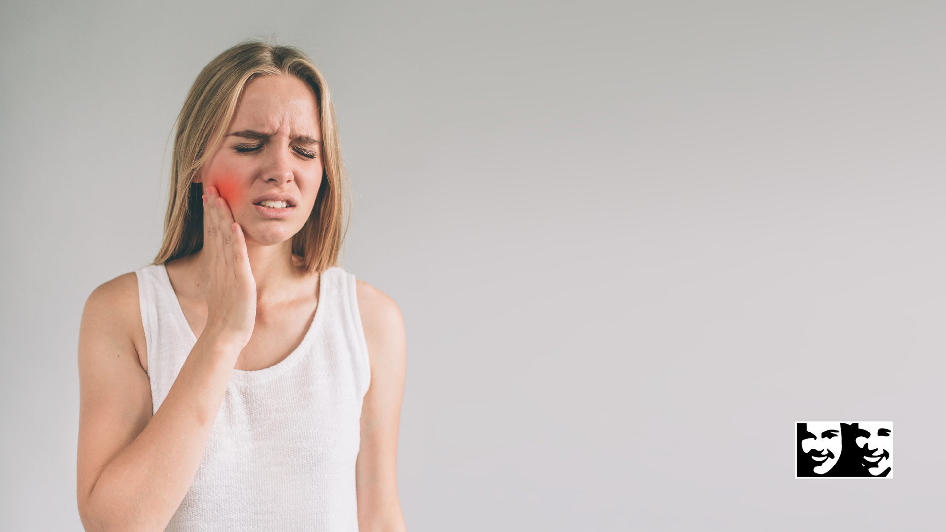 A woman is holding her face in pain because of a toothache.