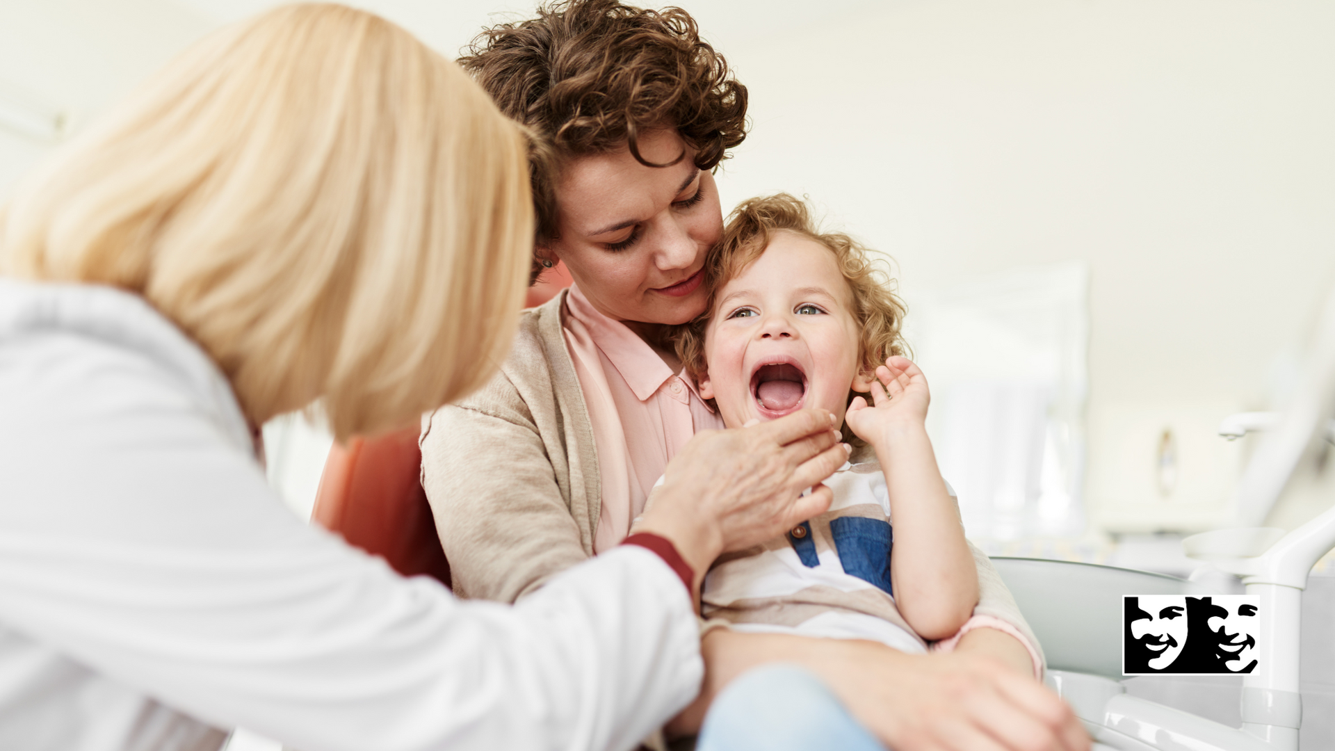 A woman is holding a baby while a doctor examines it.