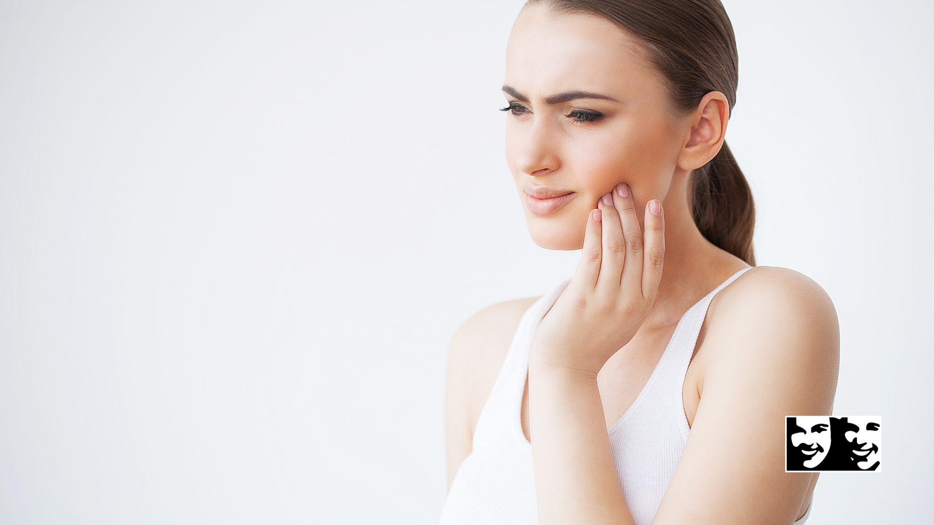 A woman is holding her face in pain because of a toothache.