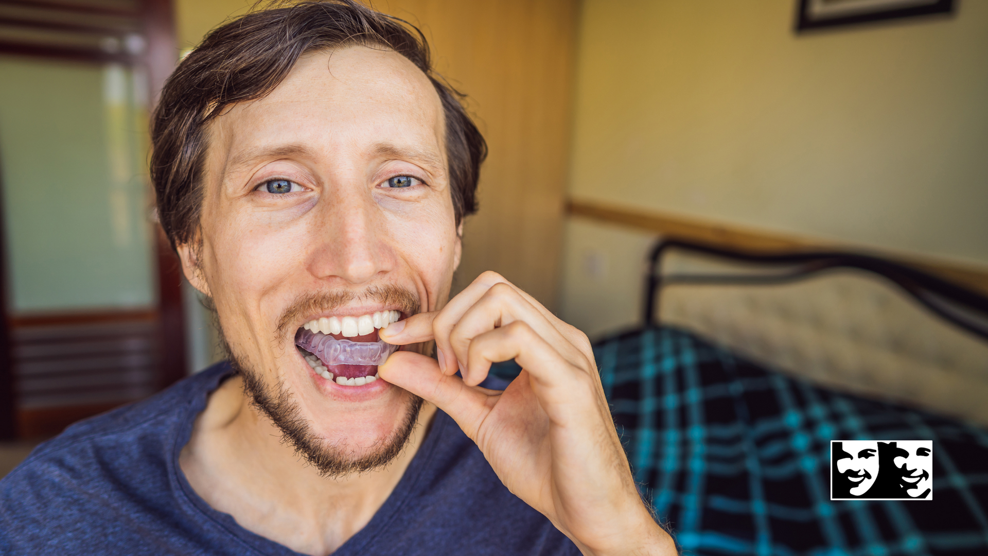 A man with a beard is holding something in his mouth.