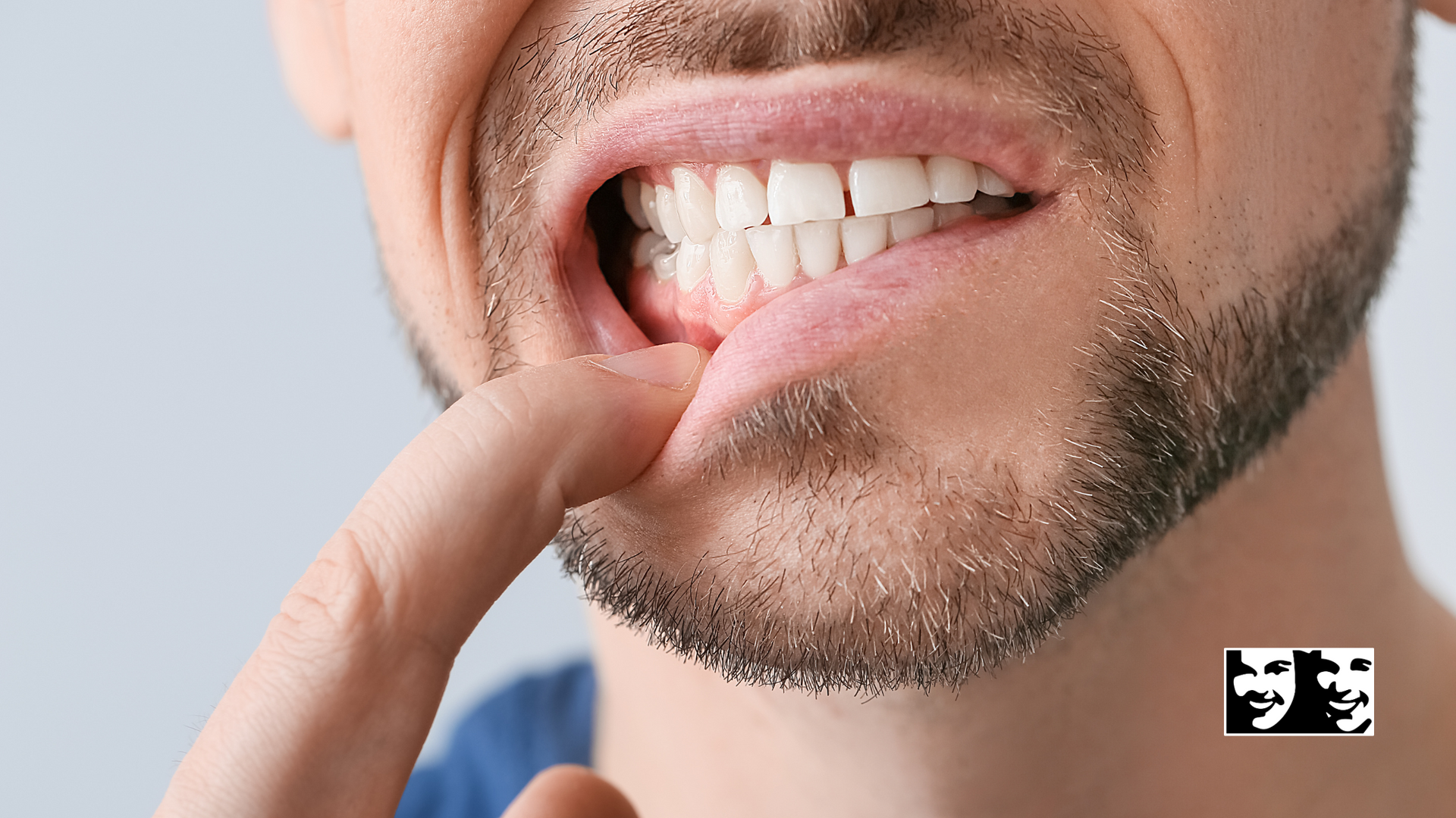 A man with a beard is holding his finger to his mouth.