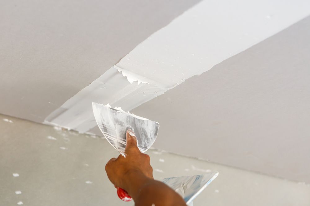 A Person is Plastering a Ceiling With a Spatula — Timeless Painting In Umina Beach, NSW