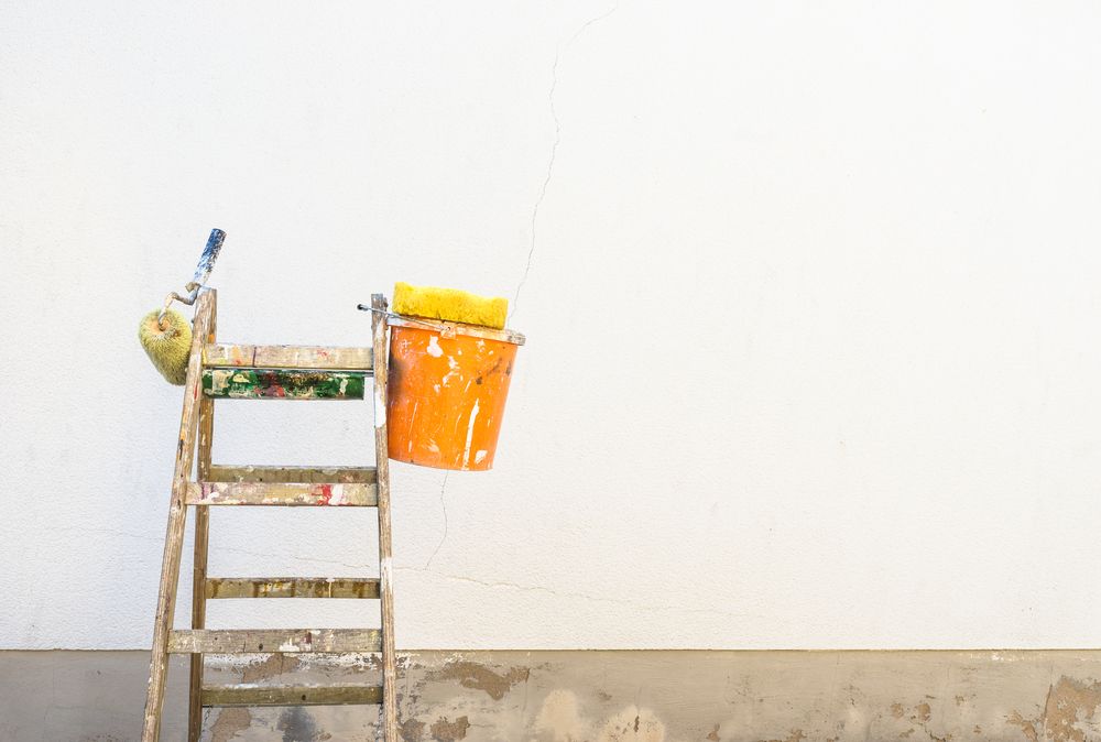 A Wooden Ladder With a Bucket of Paint and a Paint Roller — Timeless Painting In Umina Beach, NSW