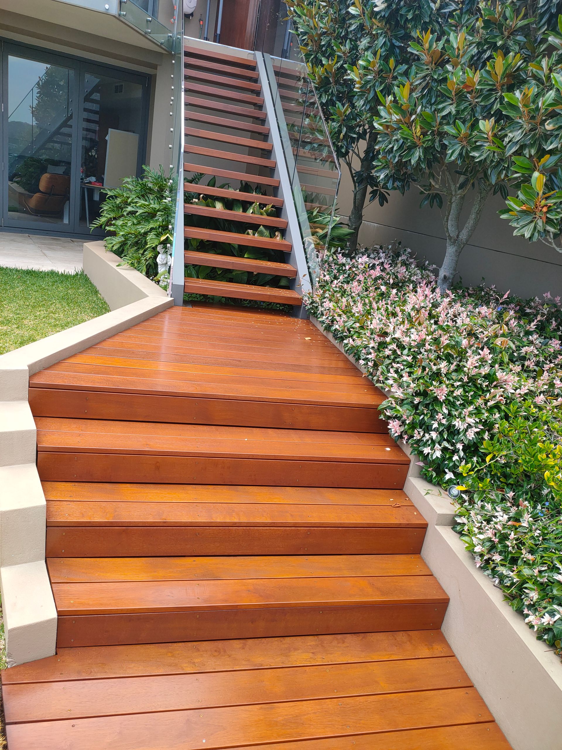 A Person is Painting a Wooden Deck With a Brush — Timeless Painting In Umina Beach, NSW