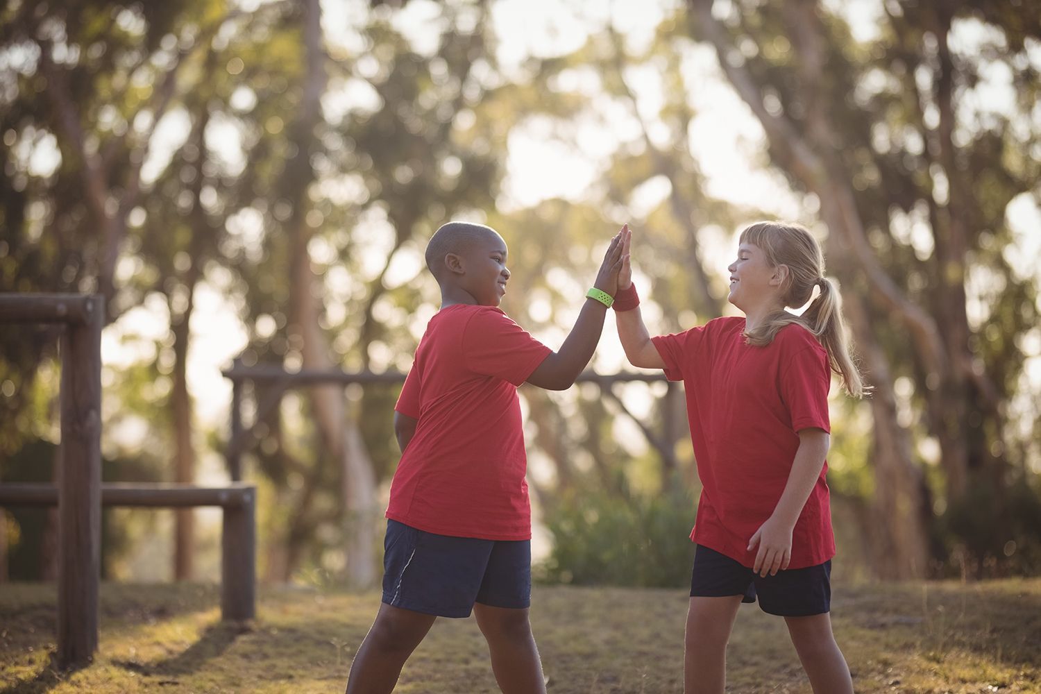 Happy kids giving high fives in a summer camp. Happy kids giving high fives in a summer camp.