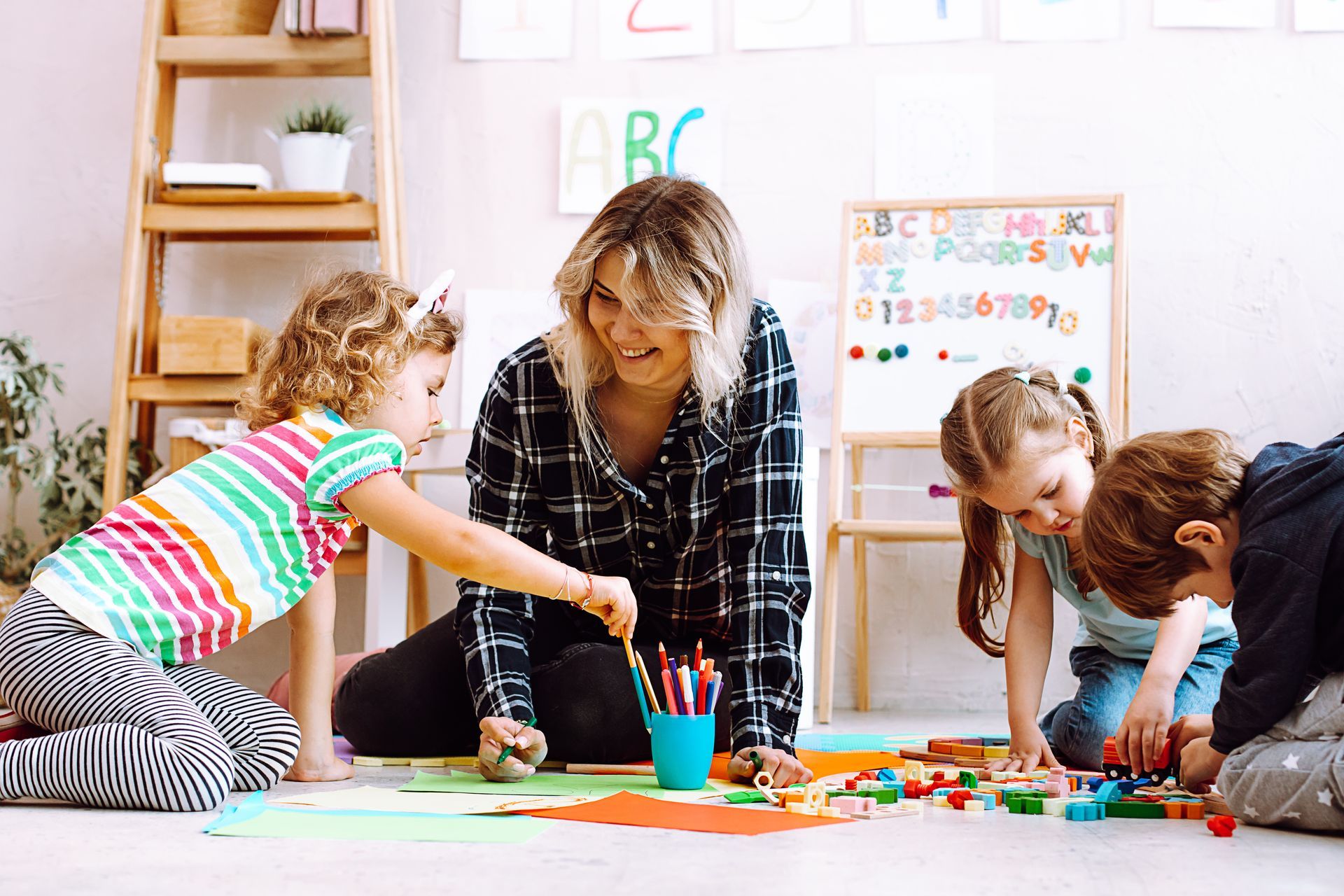 Early Childhood Education classroom with a teacher guiding children in hands-on learning activities. Early Childhood Education classroom with a teacher guiding children in hands-on learning activities.