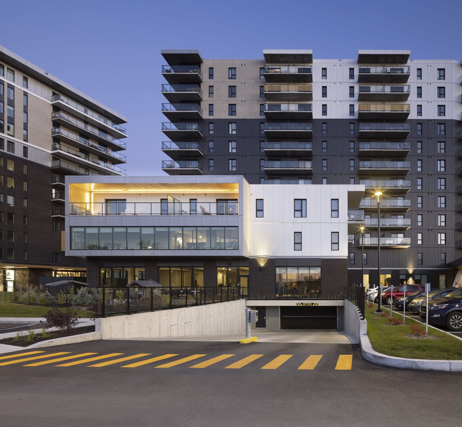 Immeubles d'appartements modernes avec entrée de garage, dotés de balcons et de couleurs variées.