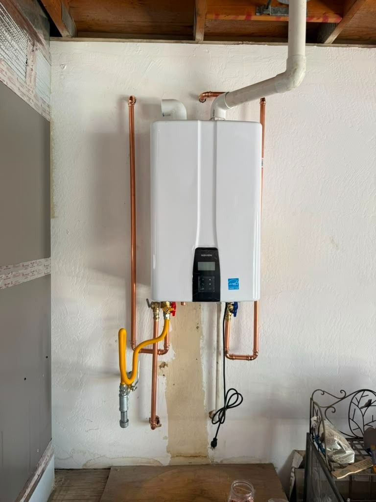 Wall-mounted white boiler with exposed copper pipes in a utility room under construction