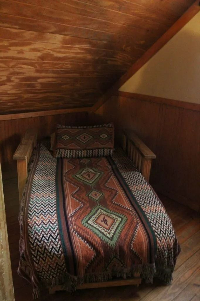 Patterned armchair under slanted wooden ceiling in a cozy attic nook