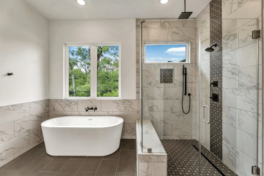 Modern bathroom with patterned tile walls, freestanding tub, and pebble shower floor.