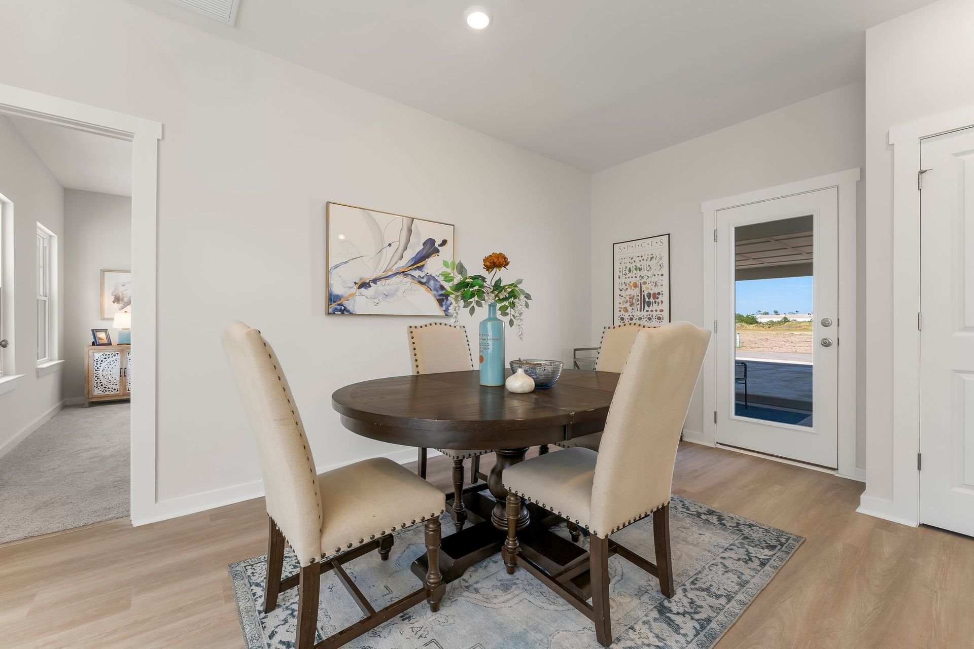 Bright dining room with round table, four chairs, and sliding glass door to the backyard.