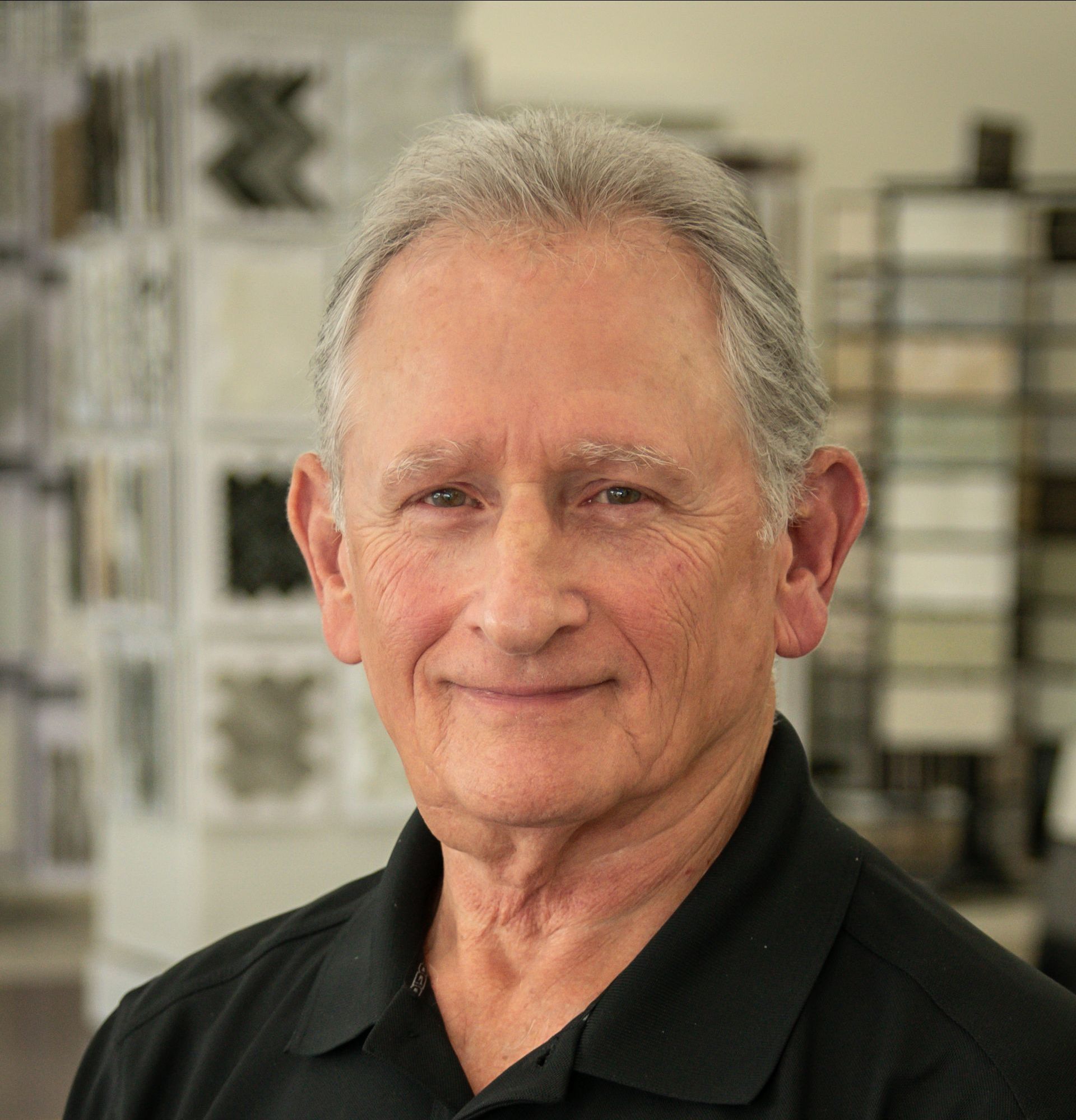A man in a black shirt is smiling for the camera in a store.
